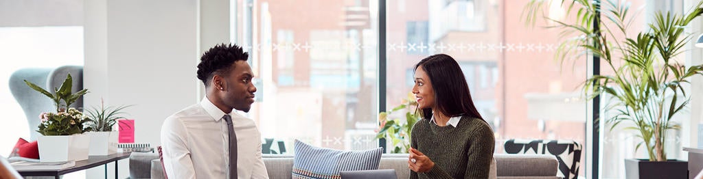 Two professionals engaged in a virtual interview conversation in a bright modern office
