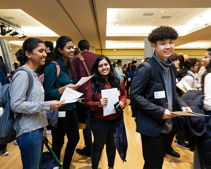 Four Mason students wait in line at the Career Fair